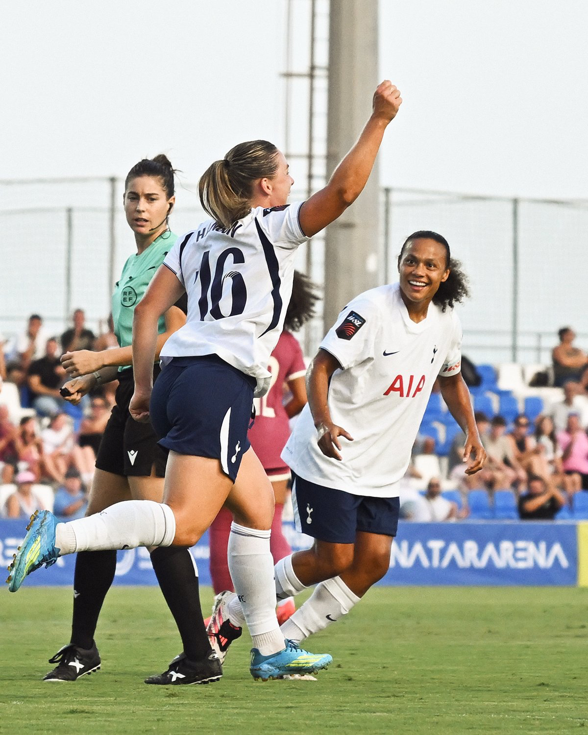 Kirsty Hanson celebrates her goal with a raised fist, Drew Spence smiling behind her.