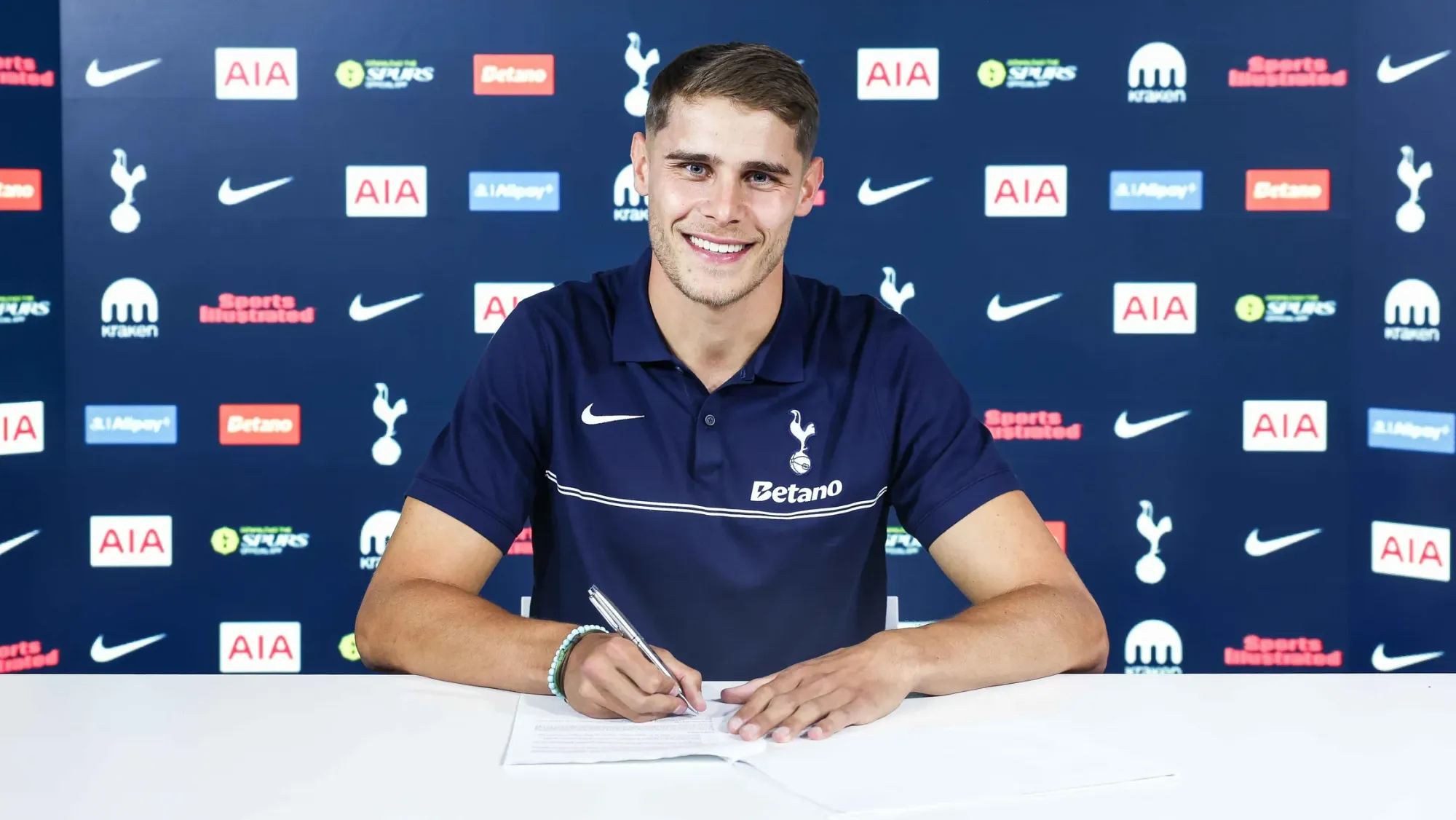 Micky van de Ven signs his contract extension.