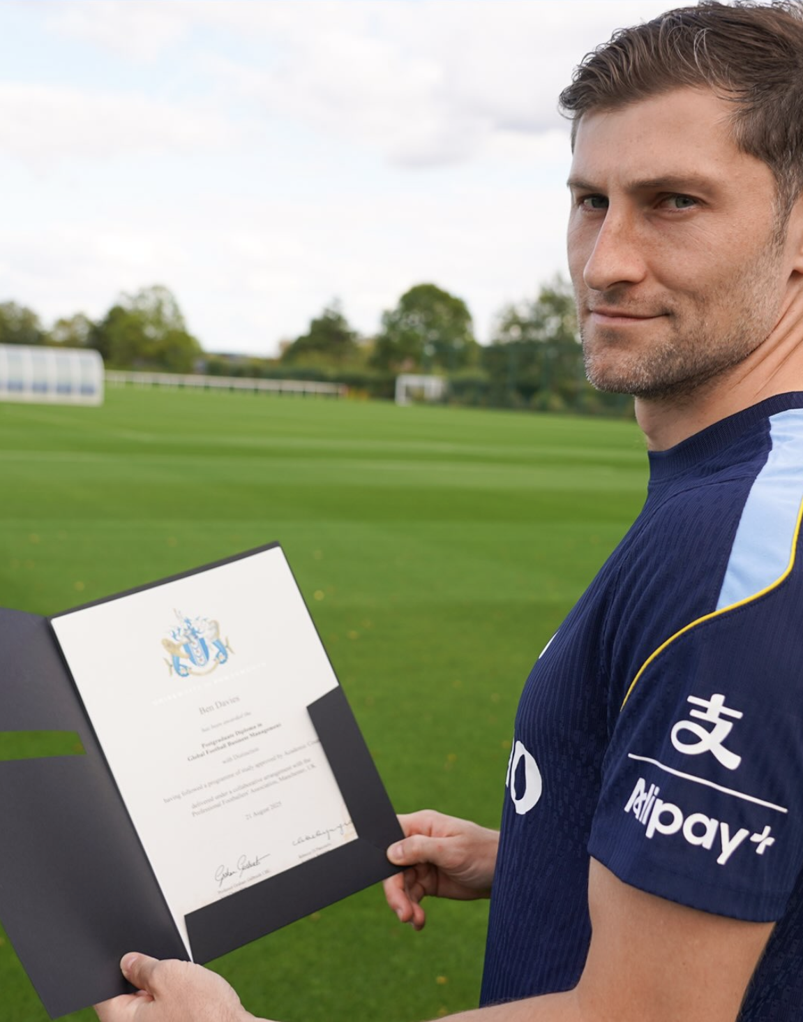 Ben Davies holds up his diploma.