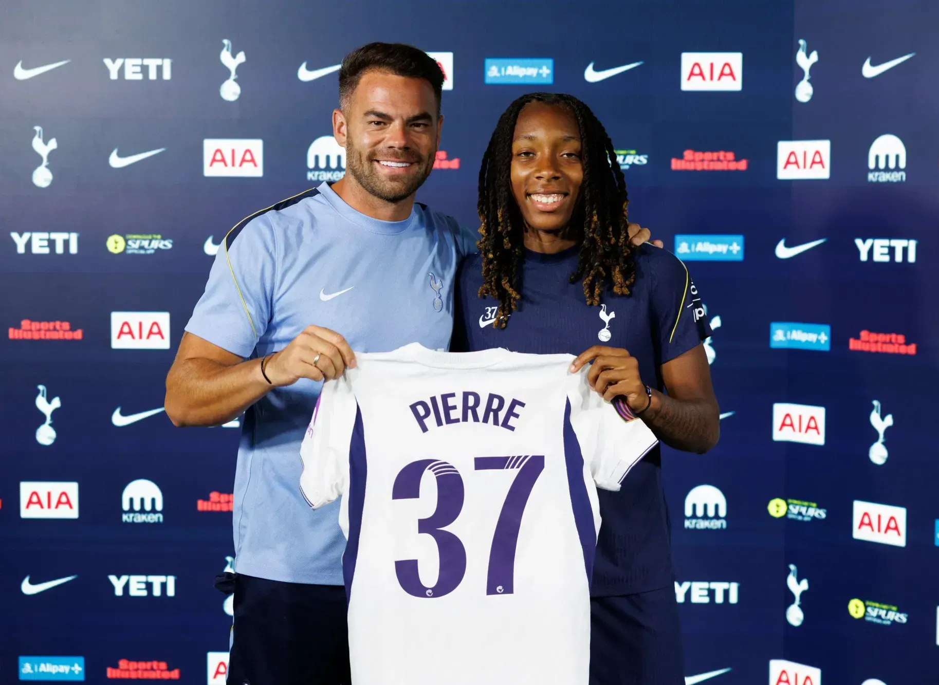 Jhanaie Pierre holds up a Spurs shirt with her name alongside Martin Ho.