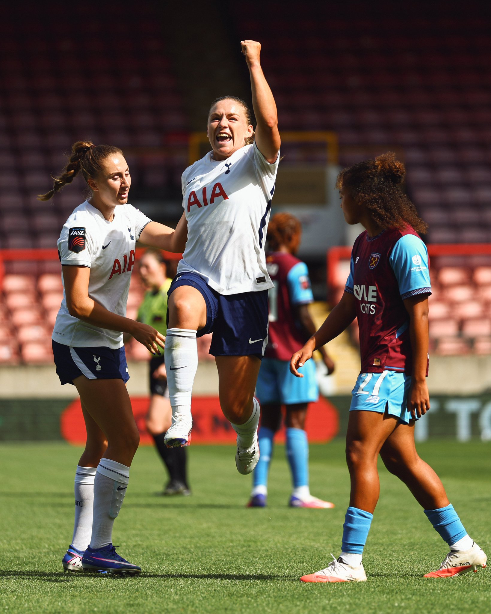 Kirsty Hanson leaps up into the air with a fist raised to celebrate her goal.