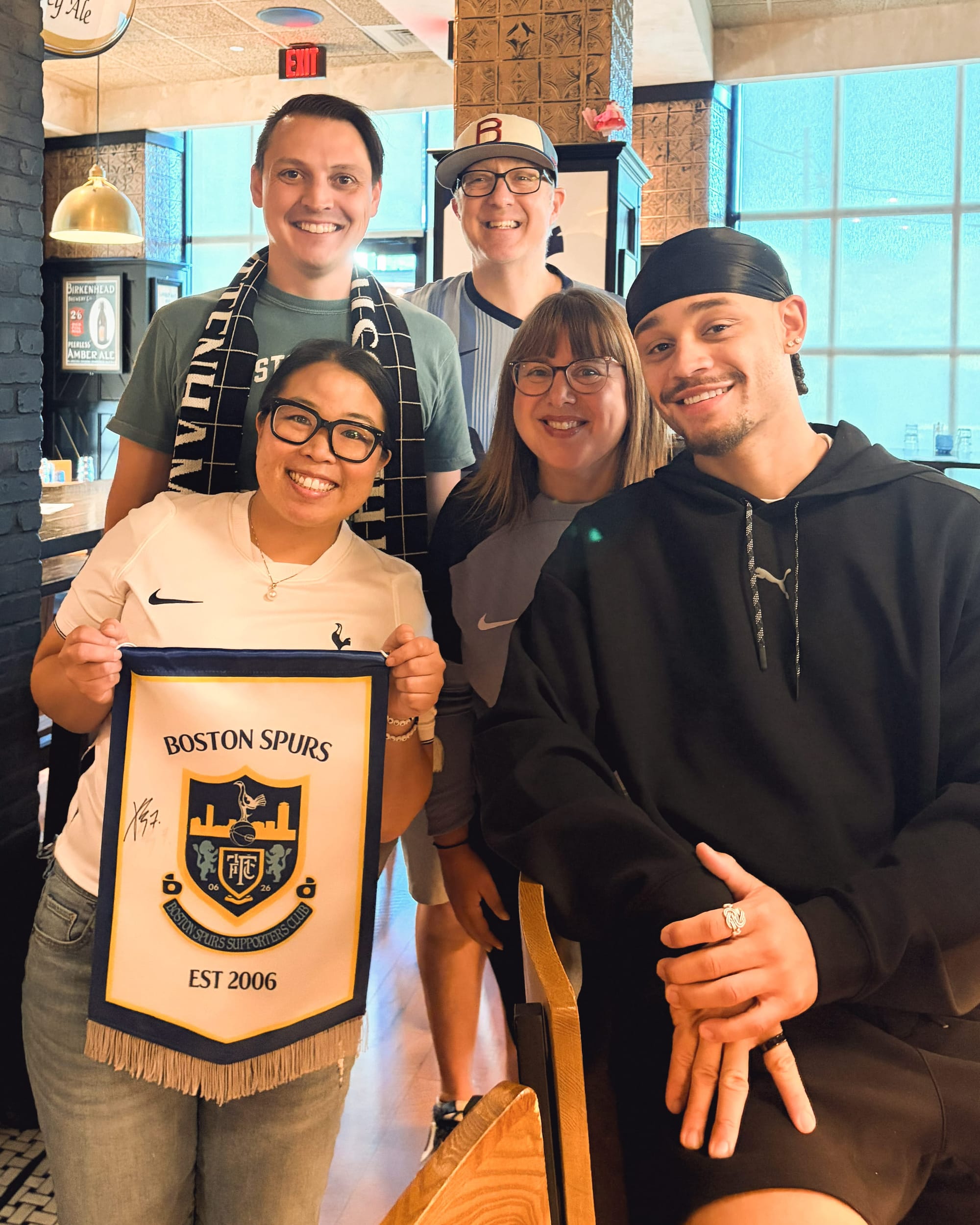 Xavi Simons poses for a photo with members of Boston Spurs.