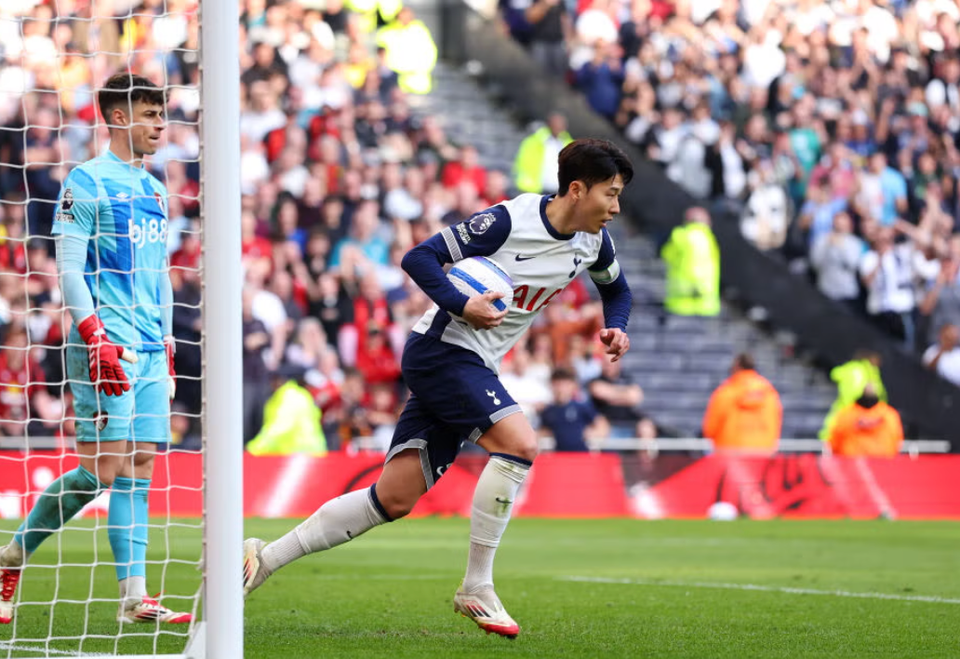 Son Heung-min carries the ball back to center circle after converting his penalty as Kepa looks on. 
