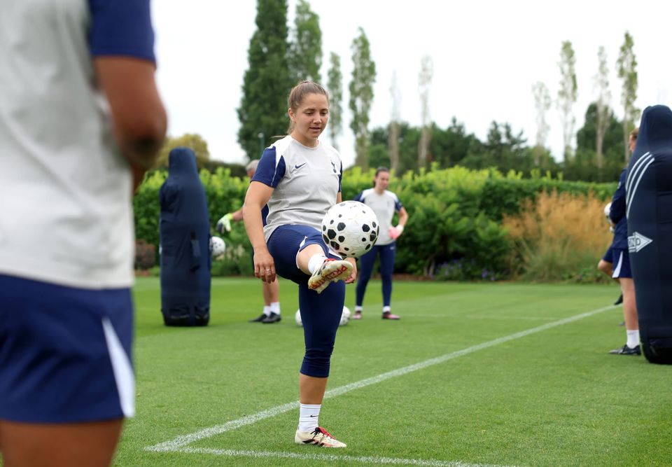 Kit Graham lifts her leg high to kick the ball in a training session.