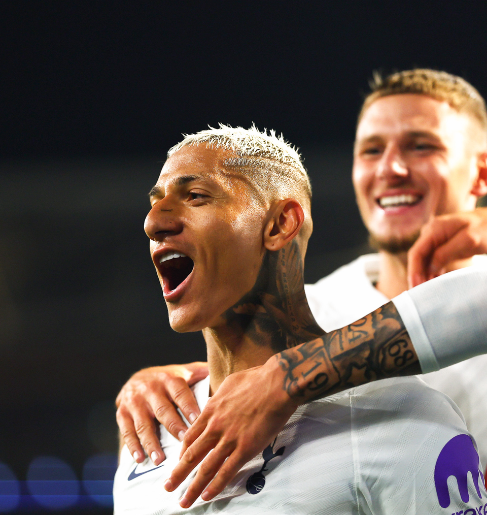 Richarlison roars after scoring a goal, Jamie Donley smiling as he goes to jump up behind him.