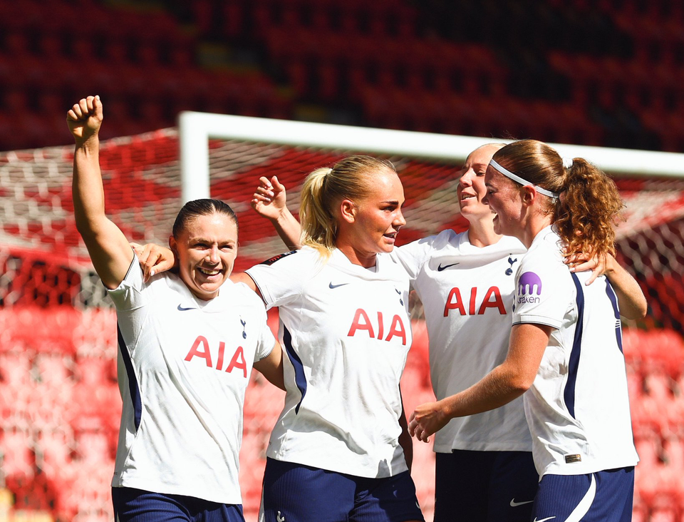 Kirsty Hanson celebrates with her teammates, raising a fist.