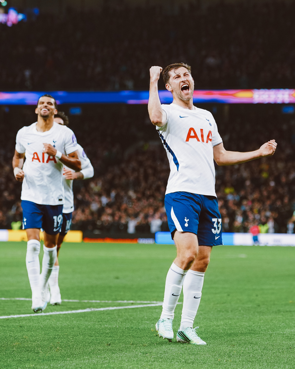 Ben Davies raises a fist in triumph, Dom Solanke jogging to catch up to him.