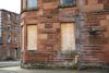 Empty tenement flat with boarded up windows