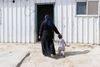 A woman wearing a niqab walks with a toddler.