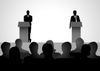 Illustration of two silhouetted politicians standing behind podiums on a stage facing an audience of seated silhouettes.