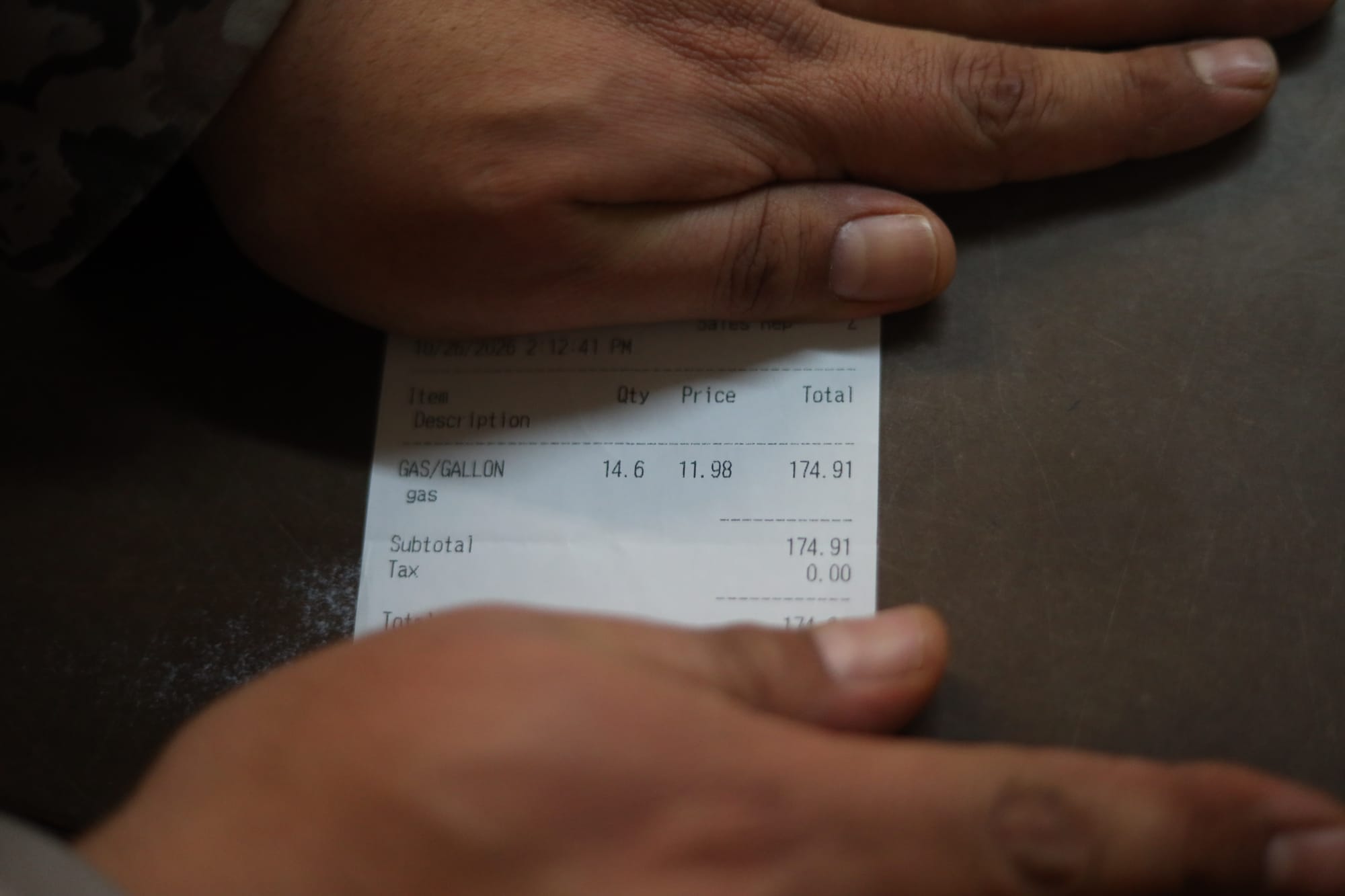 A customer at a store in Iliamna shows a receipt for a gas purchase Monday. (Nathaniel Herz/Anchorage Press)