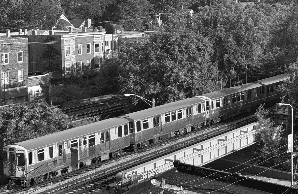 Black and white photo of a CTA L train crossing an overpass. 