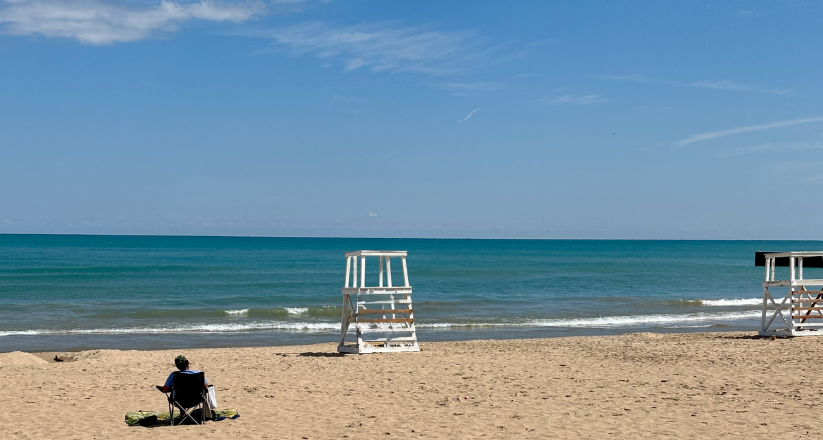 Lone individual sitting in a beach chair on Lake Michigan beach