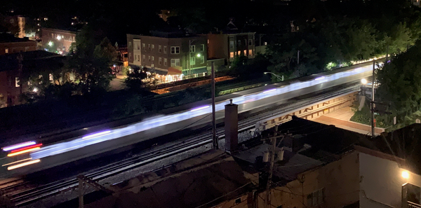 CTA L train in motion, blurred image at night.