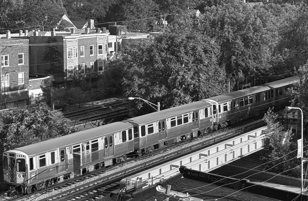 Black and white photo of a CTA L train crossing an overpass. 