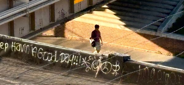Man walking under CTA train tracks bridge