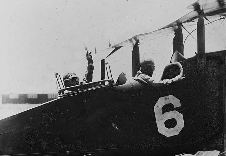 Two pilots sitting in an open-air plane, around 1920.