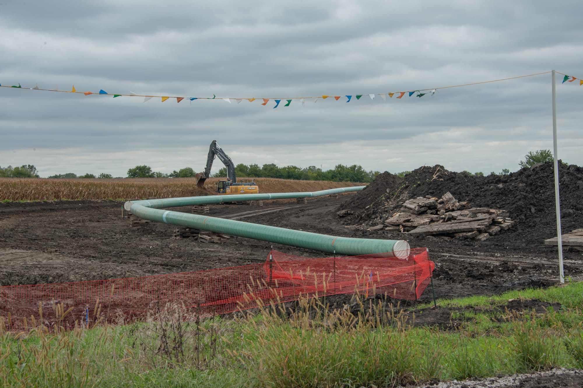 A pipeline colored light green laying in a field