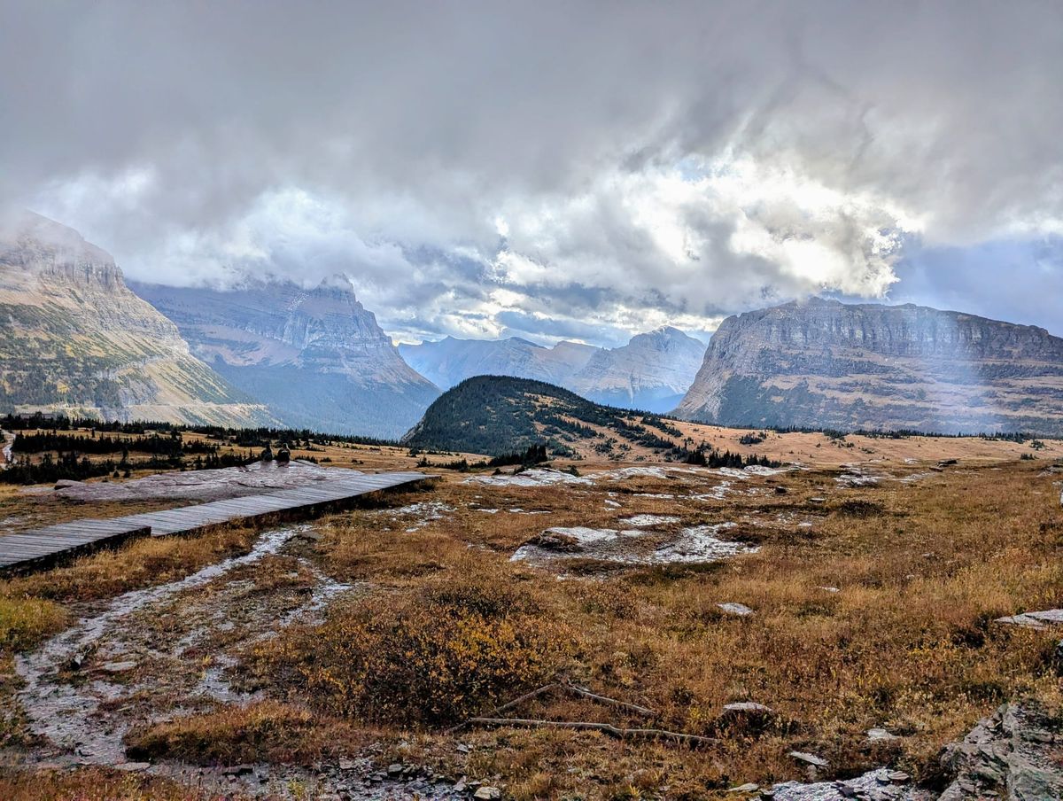 A view of mountains, meadows and a boardwalk in Glacier National Park. 