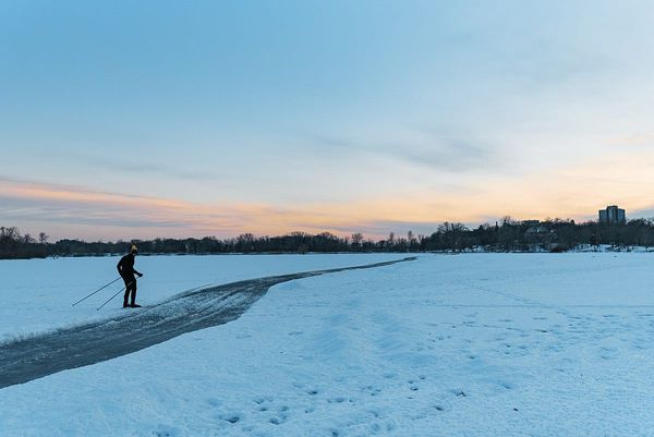 A cross country skiier skiing across a frozen lake