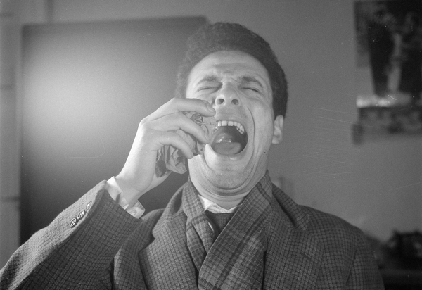 A man tilting his head back with his mouth open about to sneeze