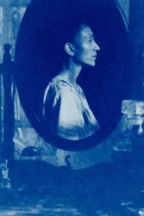 A woman reflected in an oval mirror, tinted blue, on the poster for Fatima Wardy's short White Musk