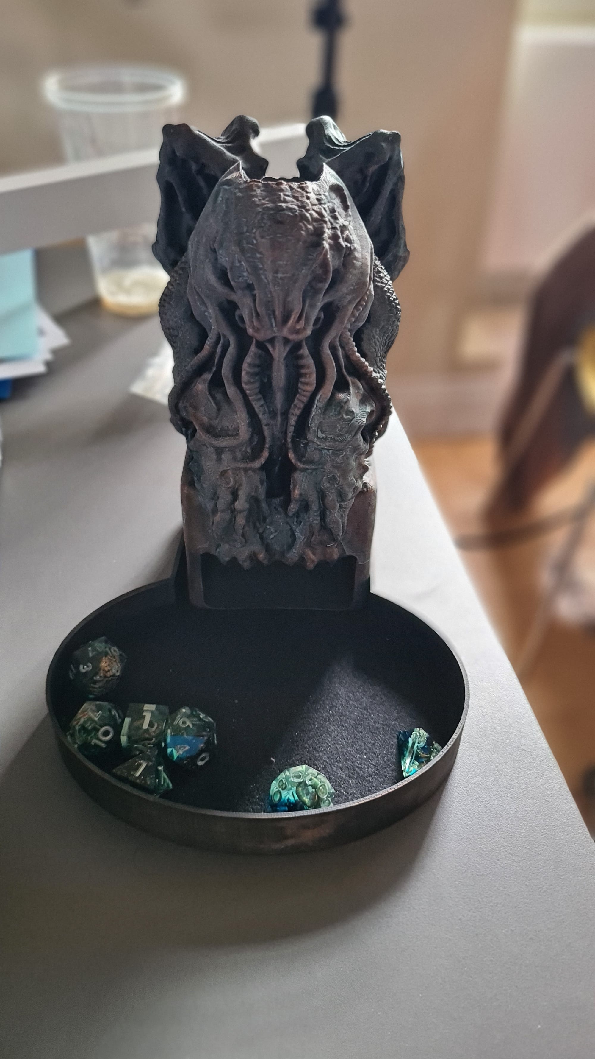 Cthulhu dice tray statue with greeny eldritch coloured dice in the tray