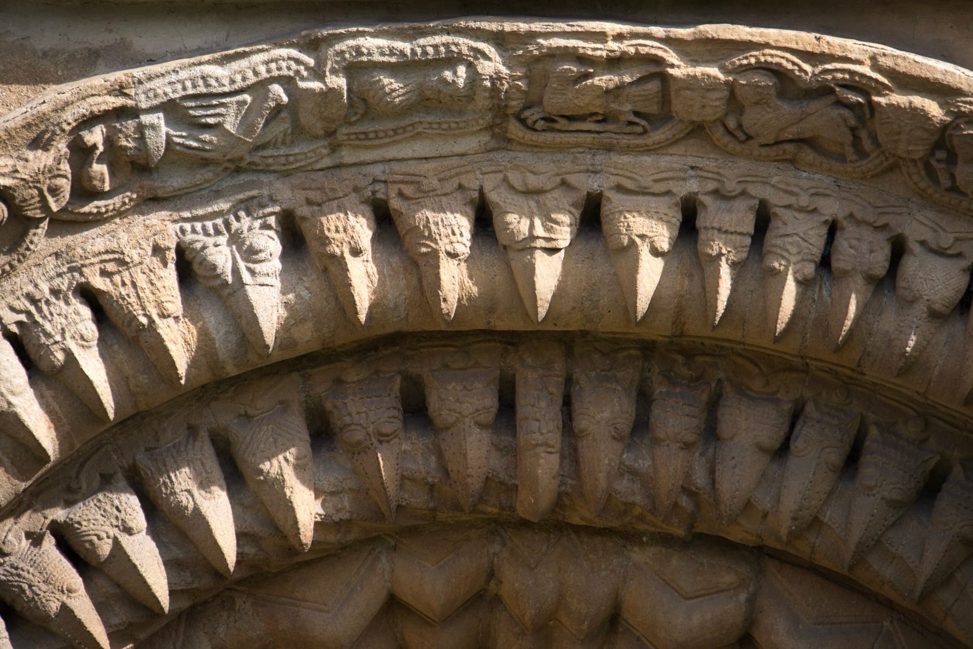 Close view of a creature-like beakhead biting a moulding at Iffley