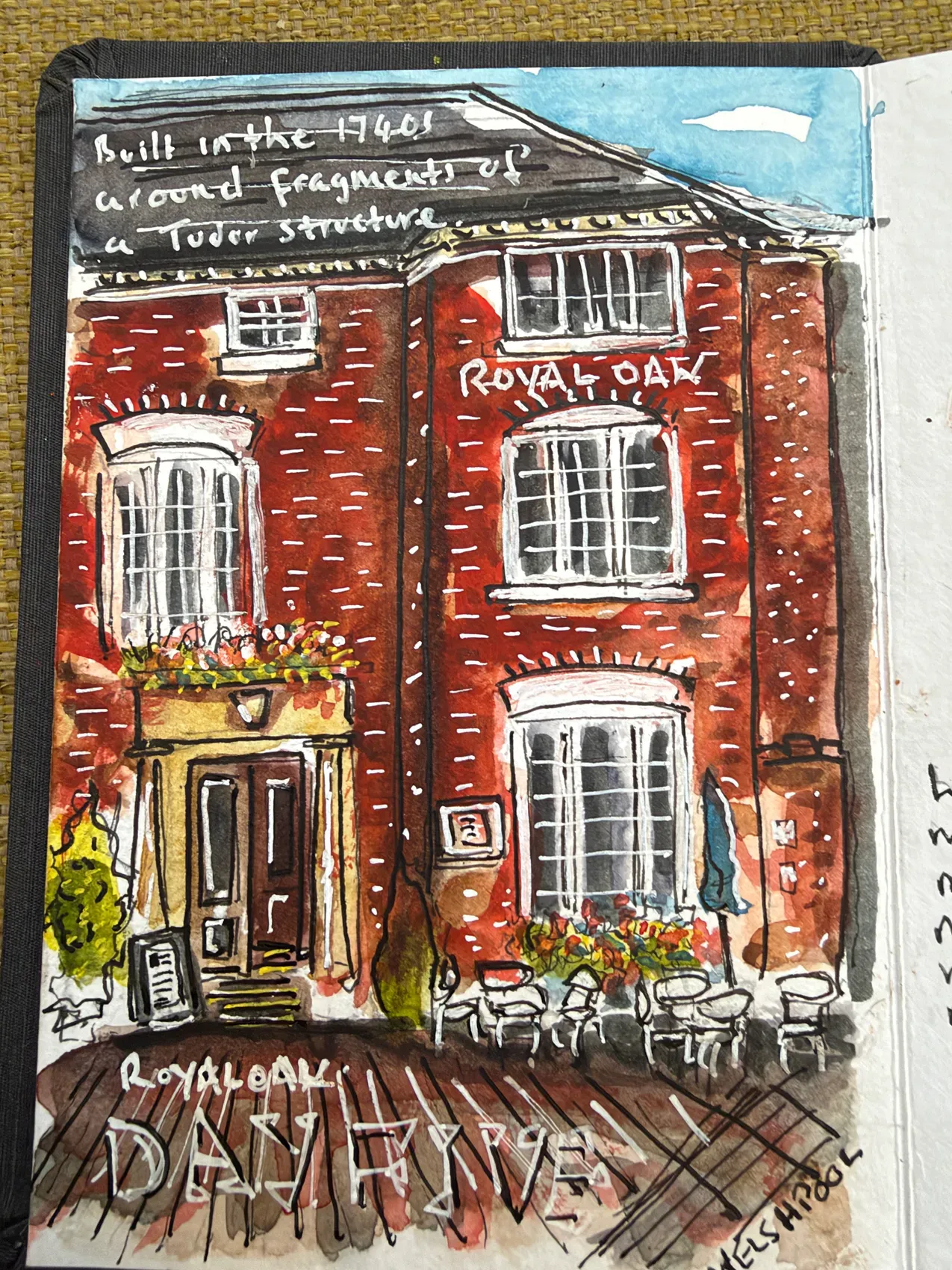 A red-brick frontage with white windows, flower boxes and café tables, painted at the Royal Oak in Welshpool.