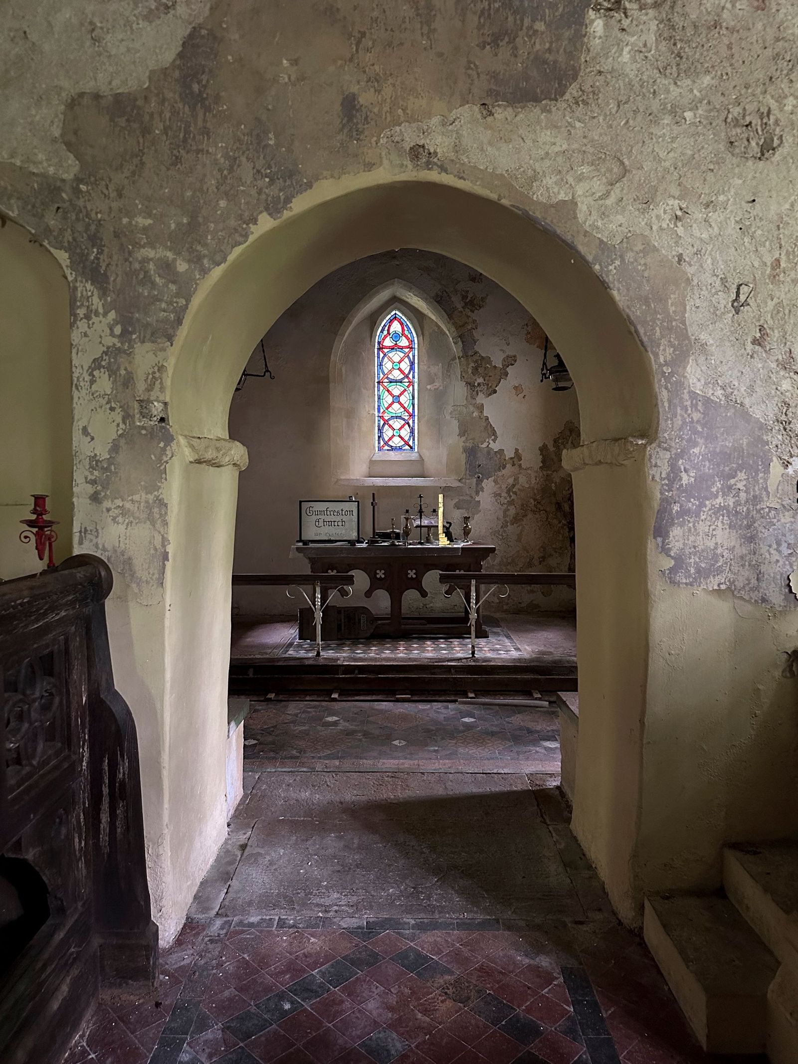Looking through the chancel arch towards the altar and stained glass at Gumfreston