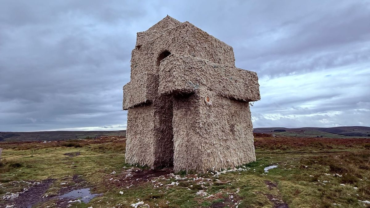 A monumental archway that from a distance looks hewn from rock but is made from the raw fleece of local sheep