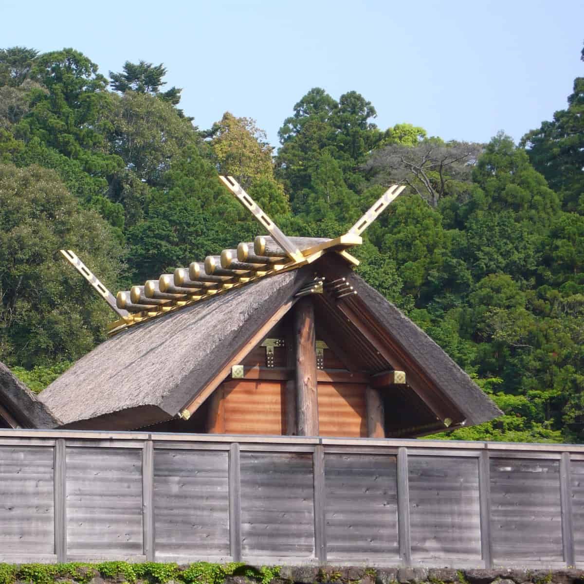 A Shinto temple behind a very mundane looking wooden fence.