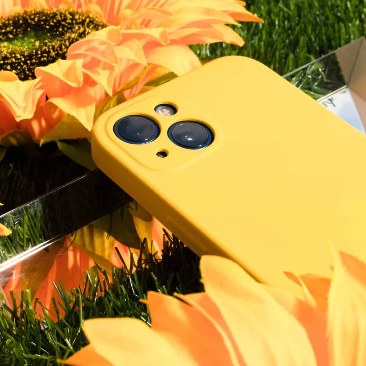 Un teléfono inteligente y algunas flores en el césped.