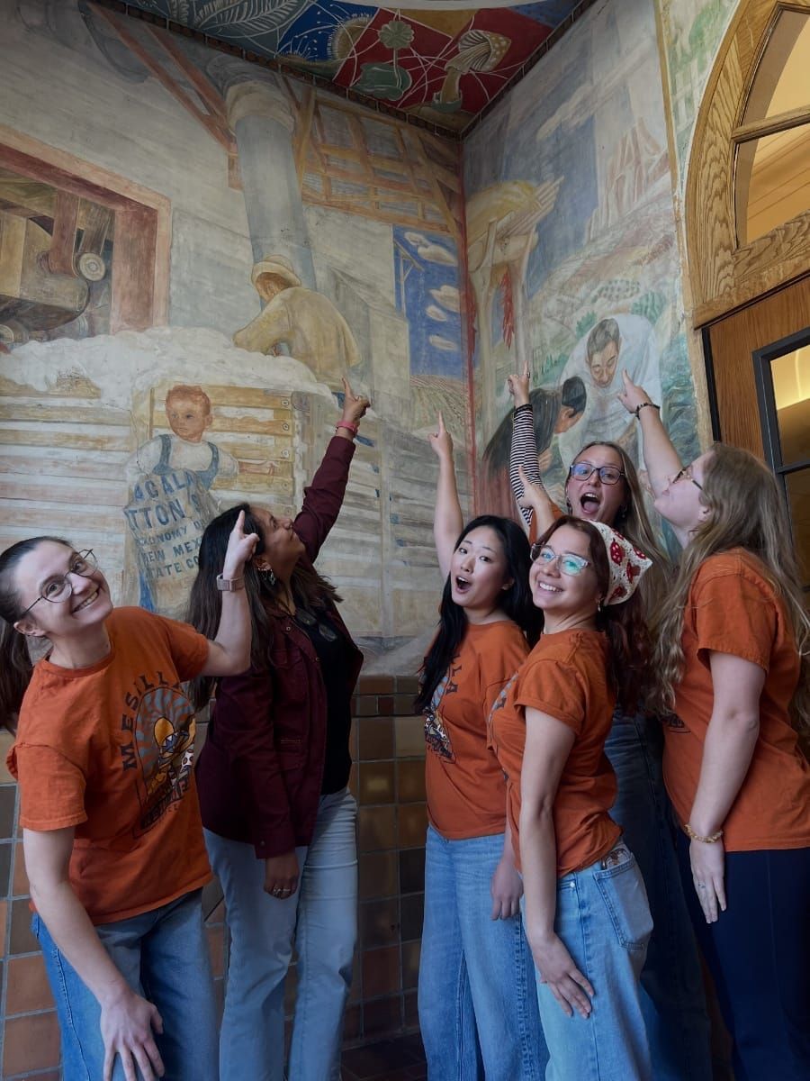 A number of young mycologists point to fungi in a fresco.