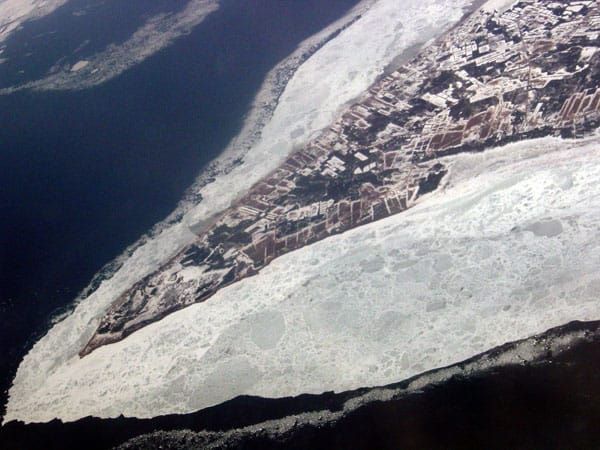 Spit of productively farmed land surrounded by sea ice