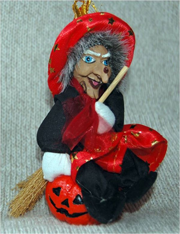 A witch with broom, pumpkins and orange clothes