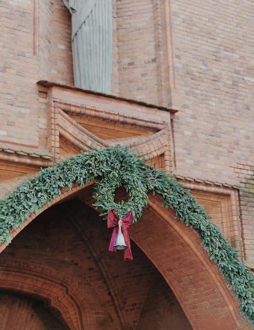 Christmas wreath with red bow and bell on building