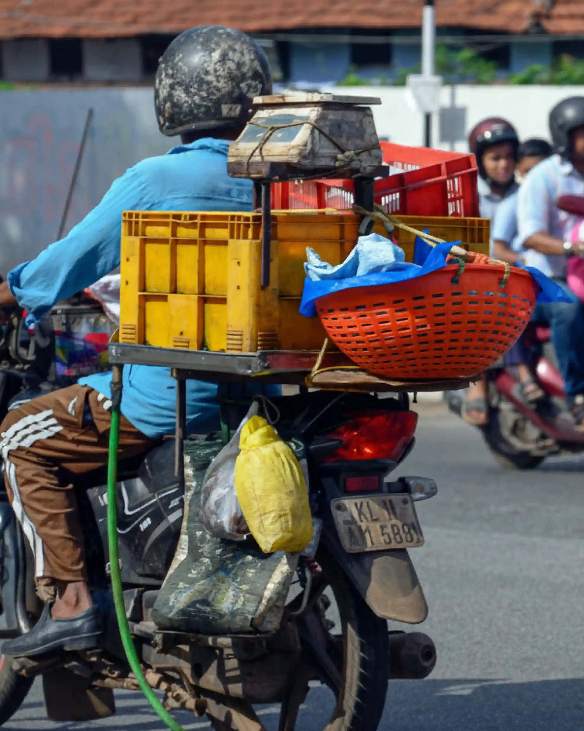 Motorcycle pillion seat and carrier modified with crates and a weighing scale for vending; example of Indian jugaad.