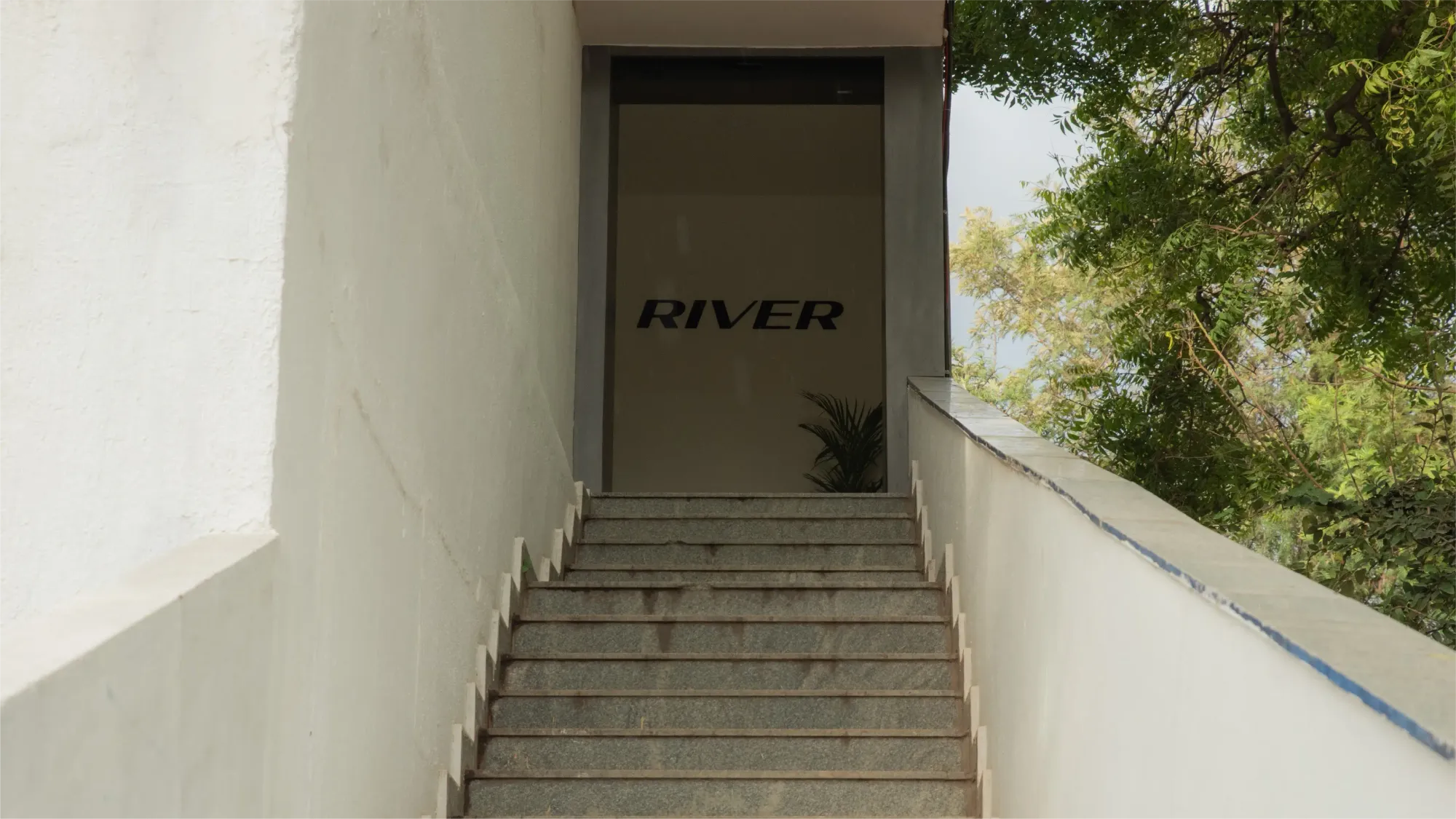 Outdoor staircase leading to the entrance of the old River office entrance, door displaying the old River logo
