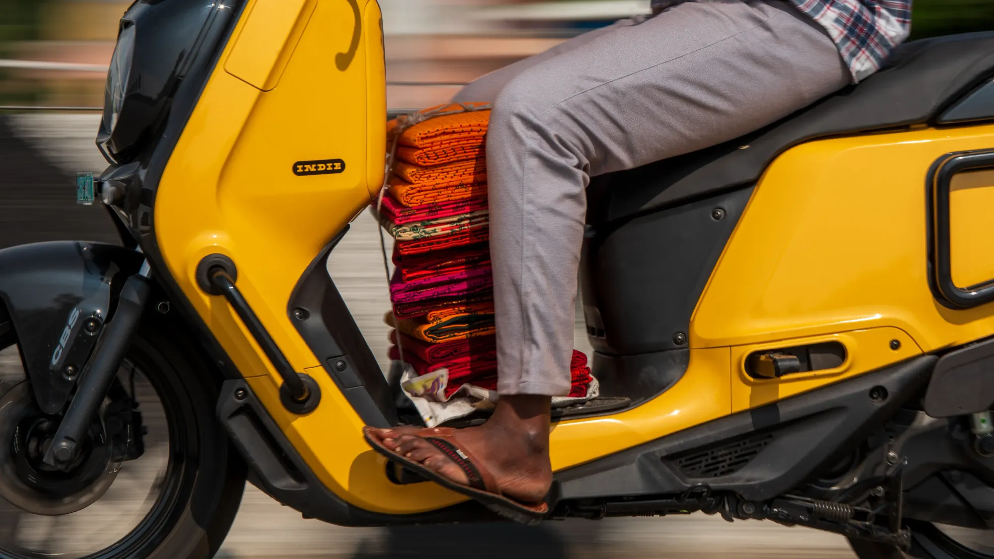 Close-up of a rider using Indie's front foot-pegs while the floorbed is loaded with folded clothes.