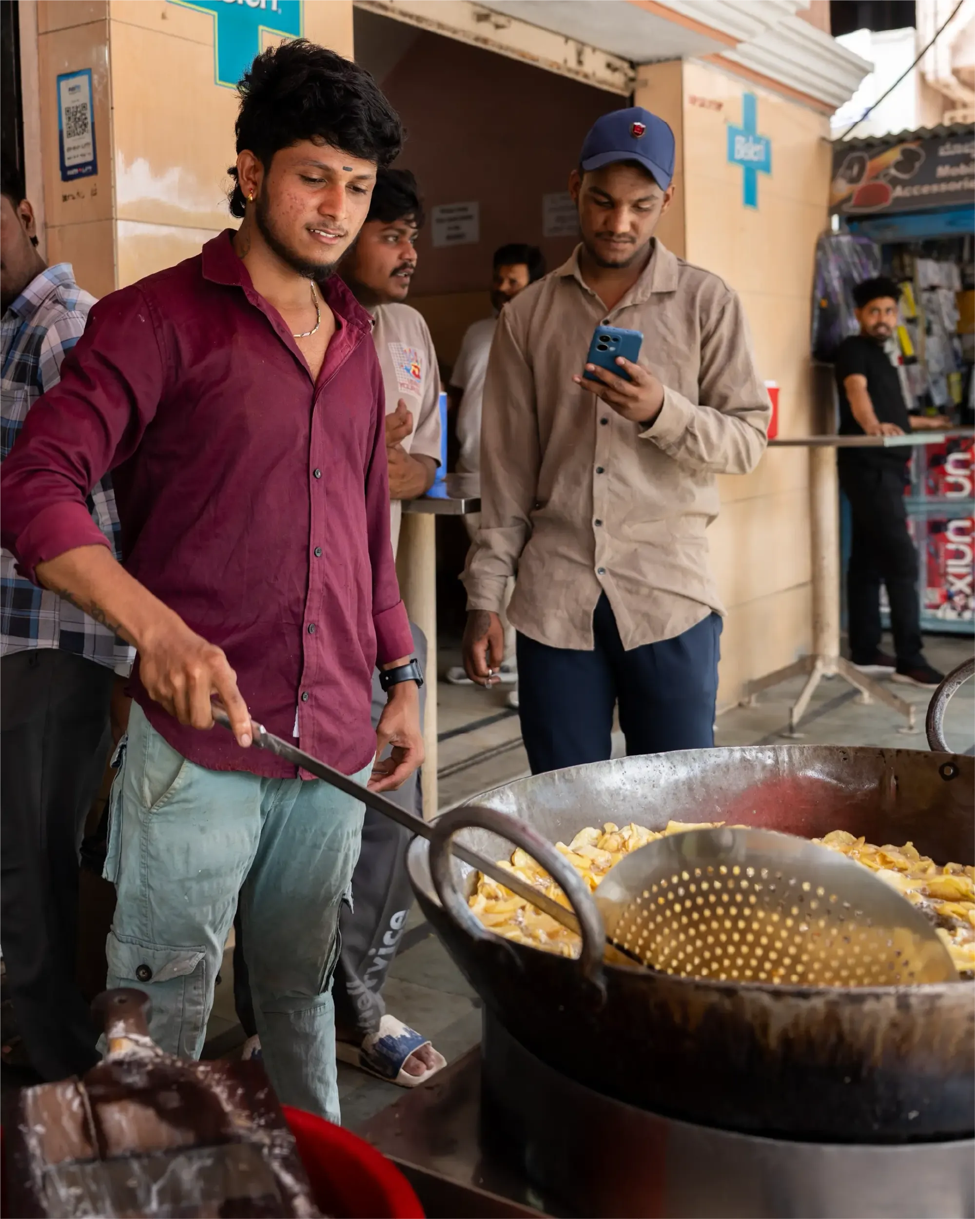 Manoj and a customer stand in front of his Hot Chips Shop
