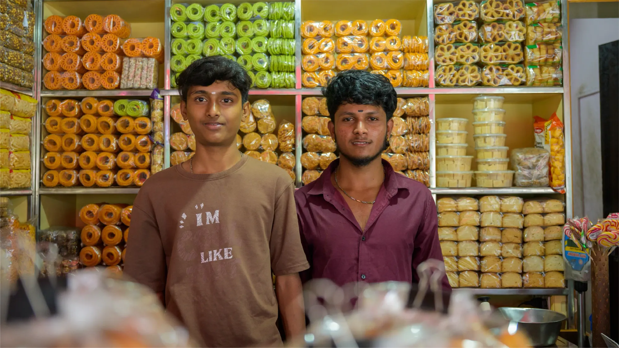 Manoj and his younger brother pose for a photo behind the shop counter