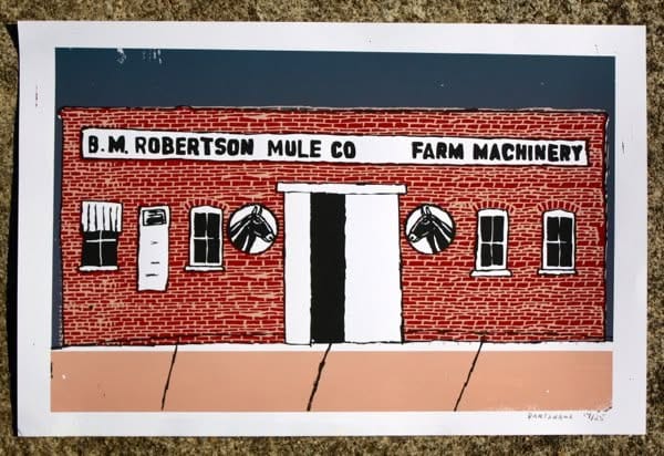 Hand-printed illustration of the red-brick B.M. Robertson Mule Co. building, with white doors, black windows, mule-head emblems and “Farm Machinery” painted across the front.