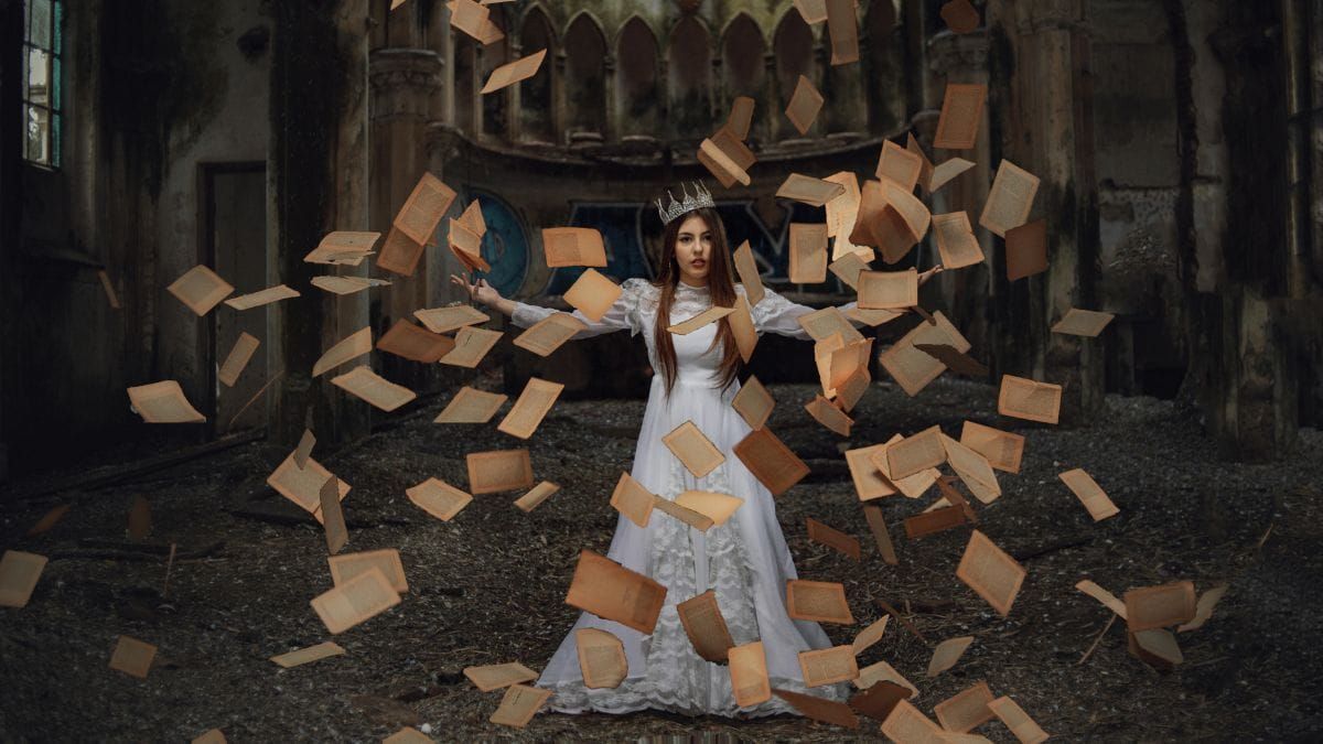 woman in a queen cosplay with old book pages flying around her