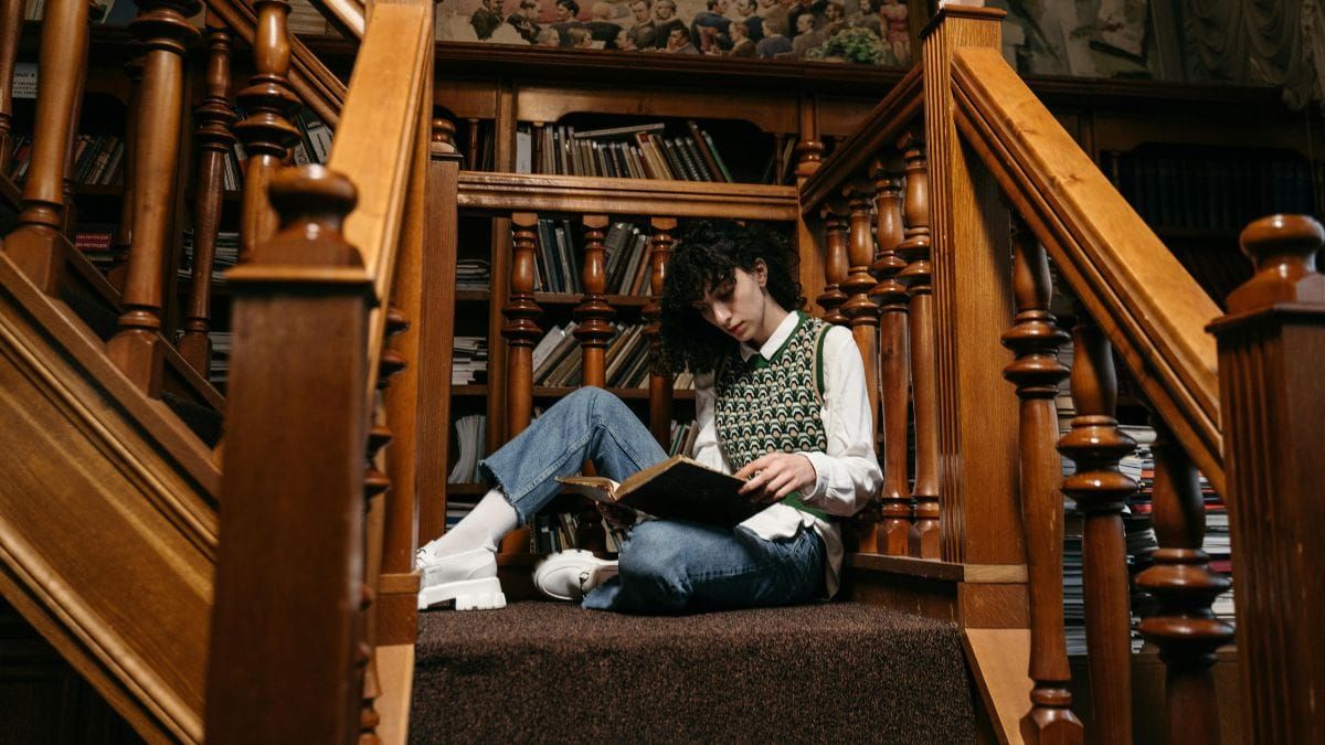 woman sitting on the stairs and reading an old book