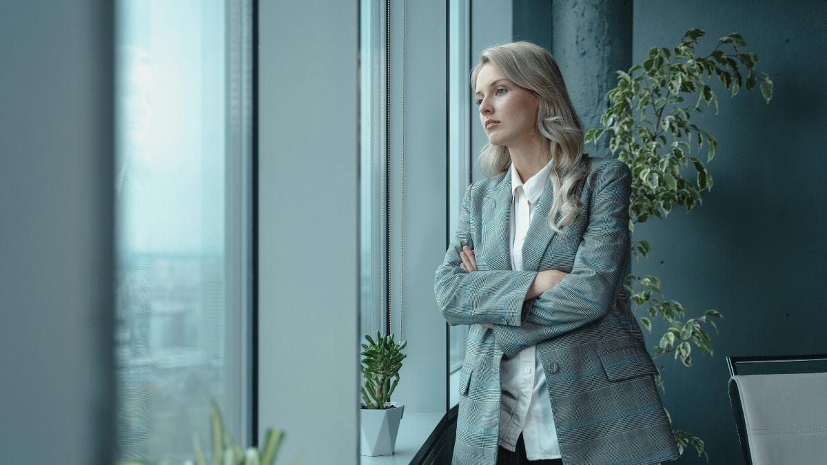 a woman with a serious expression on her face looking out the window
