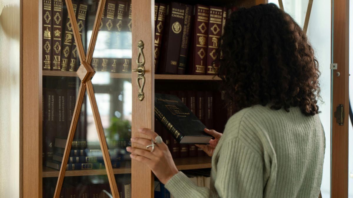 woman choosing a book from a shelf