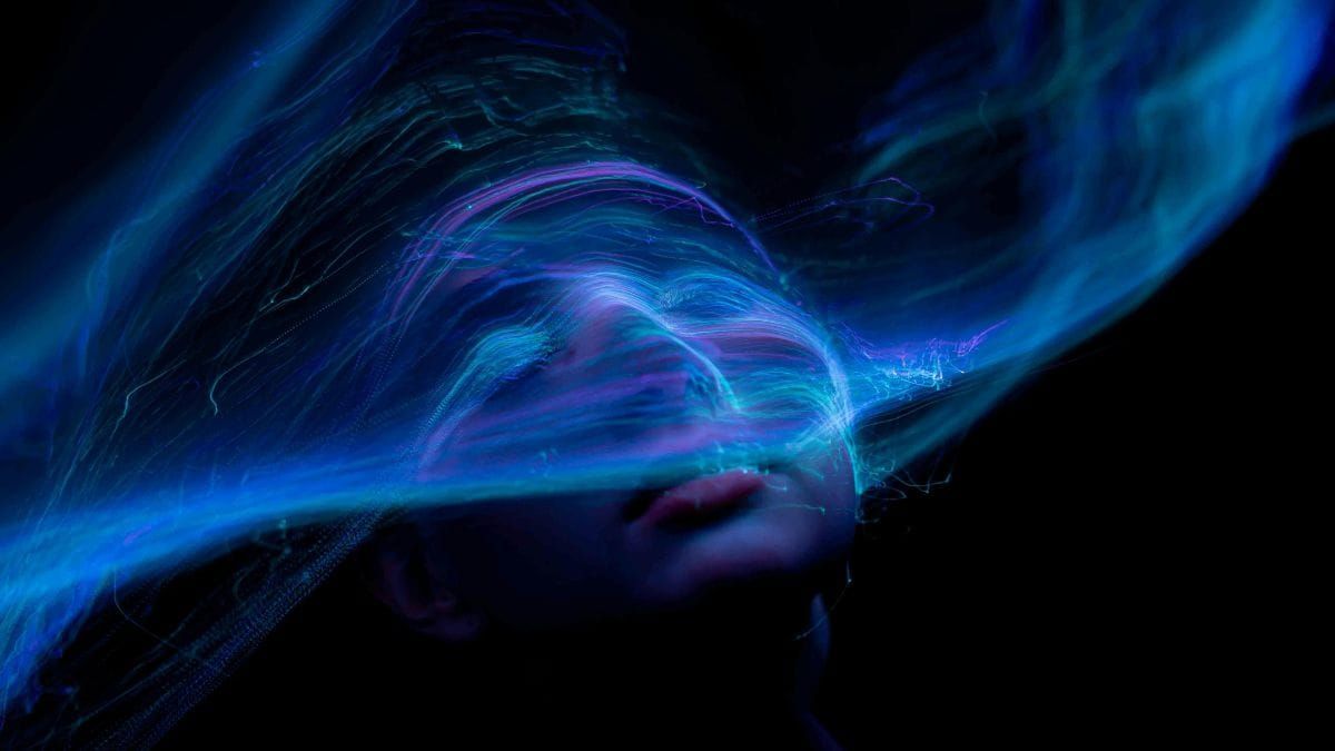 Abstract blue light illuminating a human face, symbolizing the hidden power of social media algorithms and the struggle to stay human.