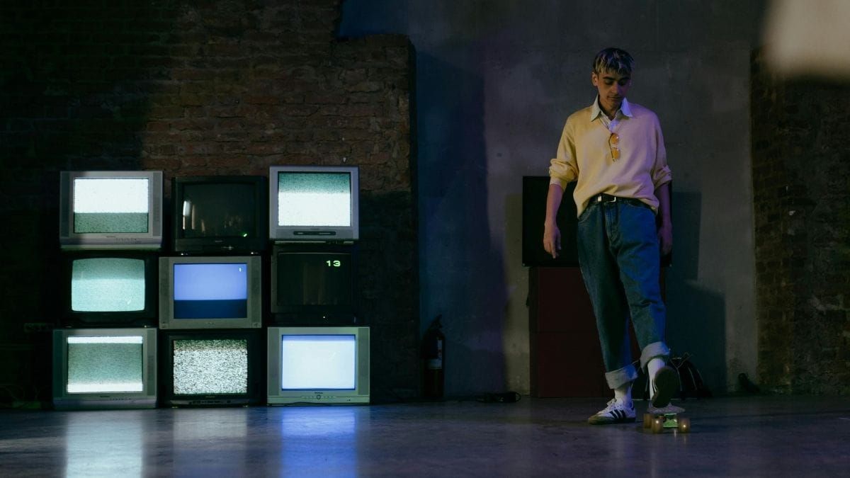 Stacked CRT televisions displaying static in a dark room.