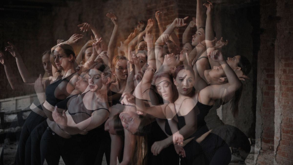 Multiple exposures of dancers repeating similar movements in a dark studio